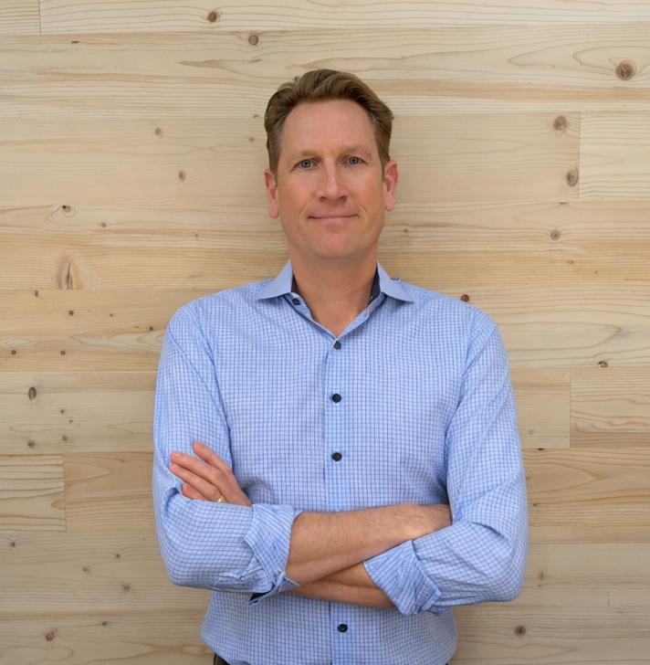 Pierce, founder of WD Walls, standing in front of a wood-paneled wall